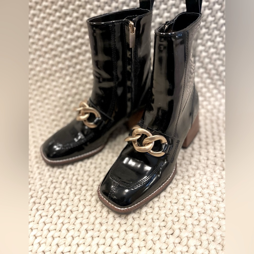 Steve Madden Lorreen ankle bootie. Black patent leather with chain detailing.